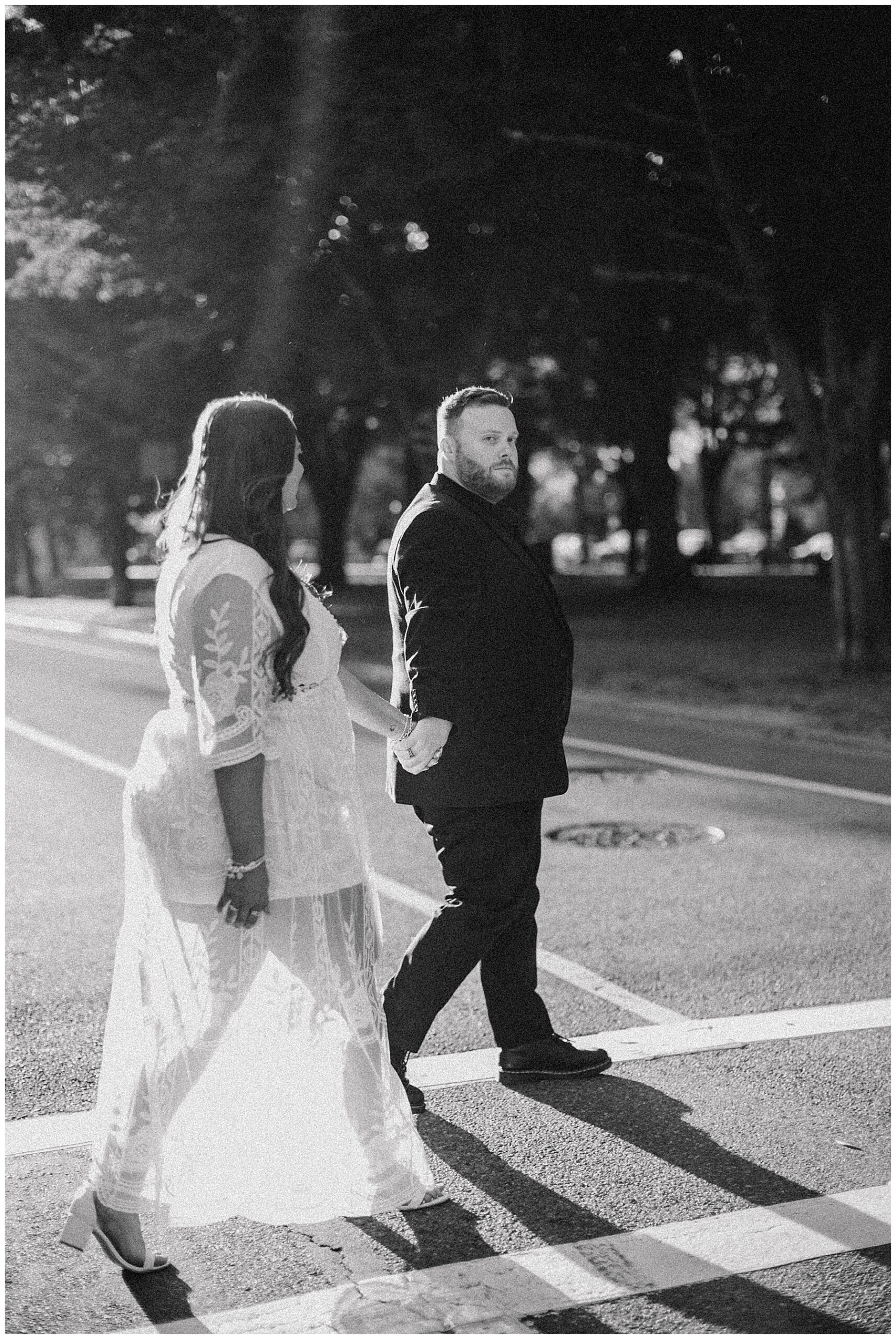 timeless engagement photo of couple holding hands while crossing the street 