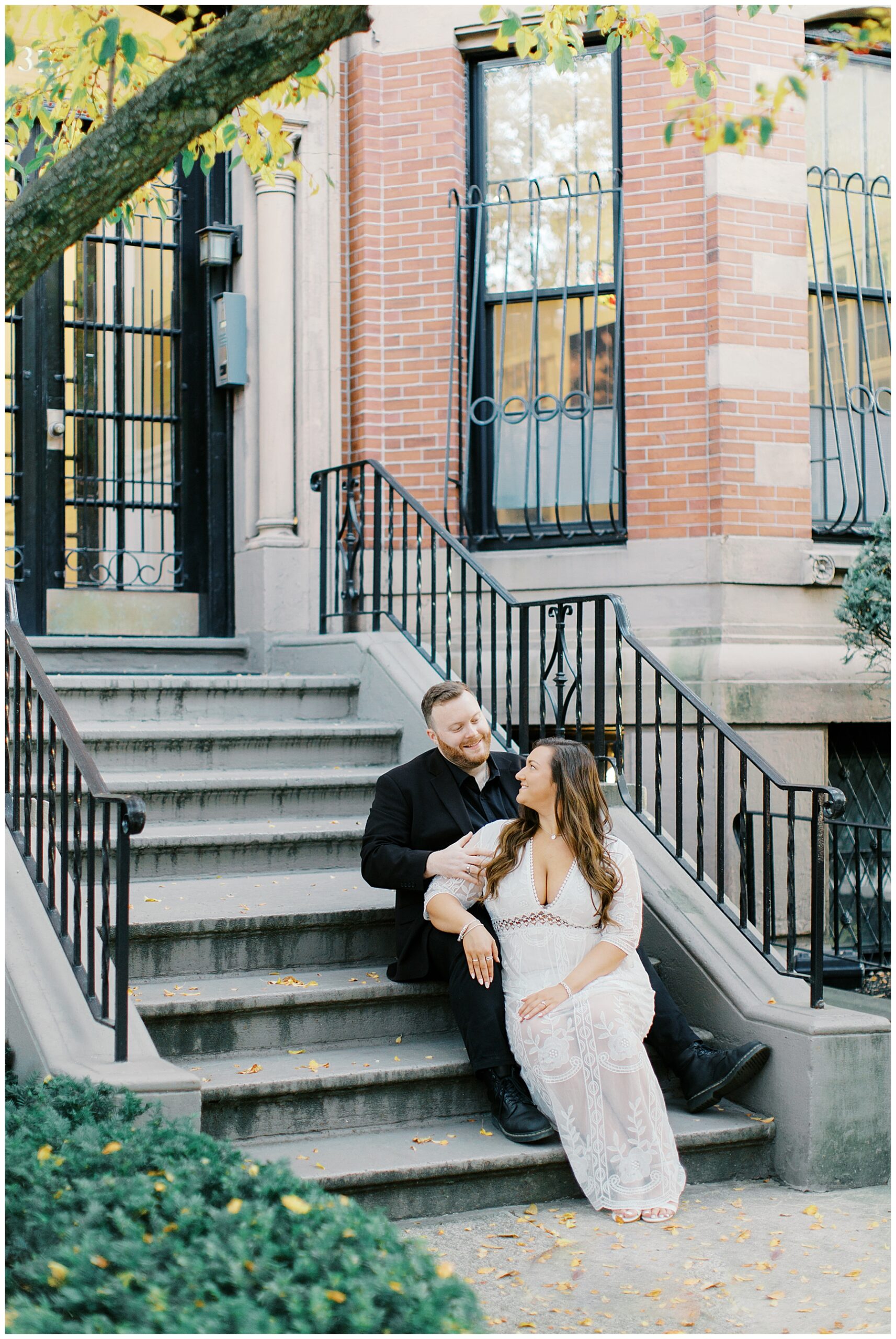 couple sit on front steps during Boston engagement session 