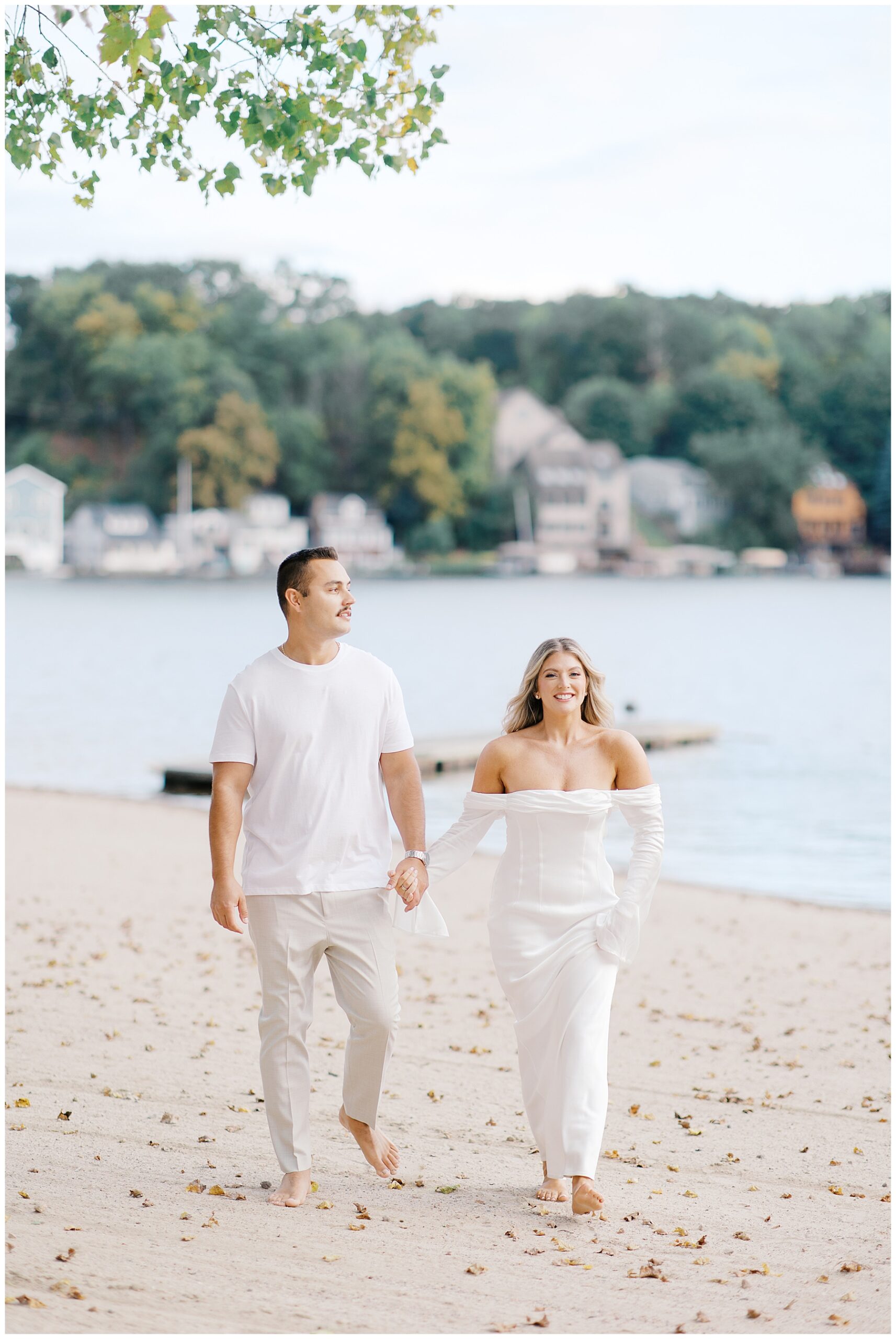 candid engagement photos as couple walk the beach