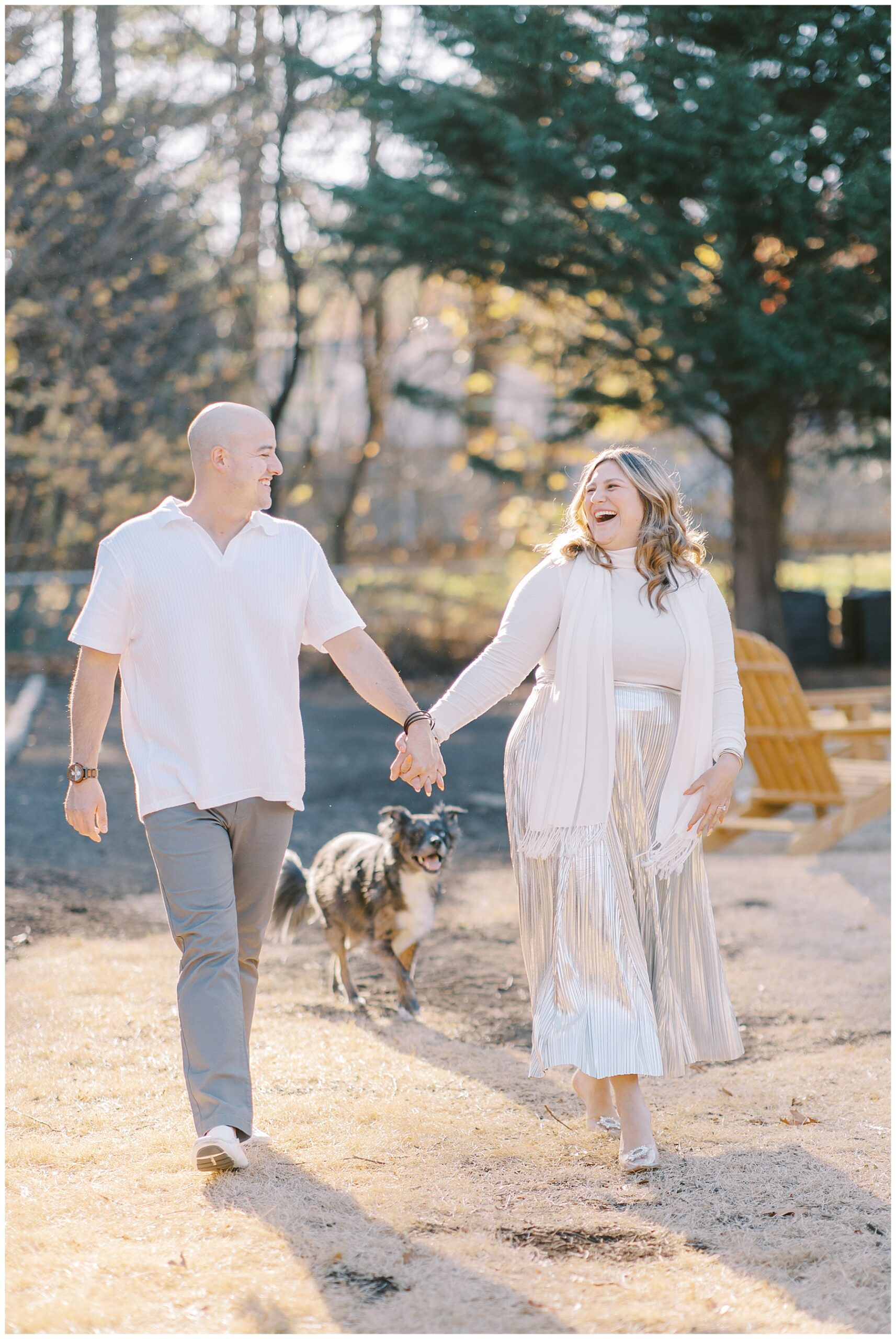 candid couple portraits of them laughing as they walk together holding hands 