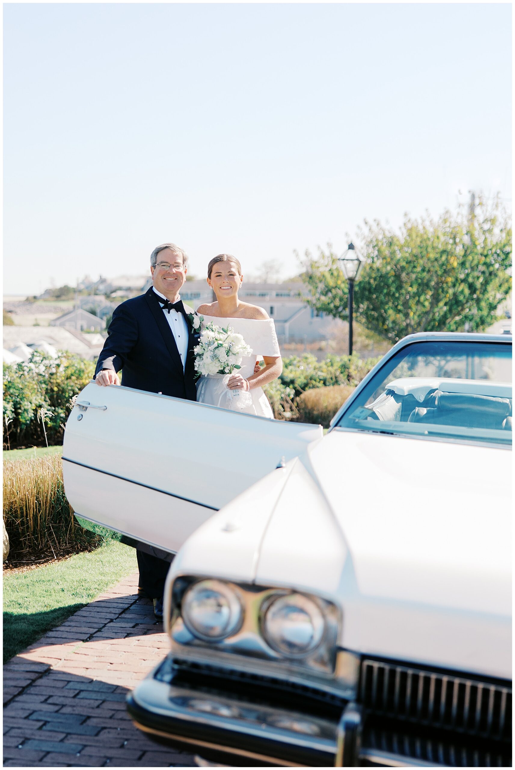 bride with father getting into vintage car 