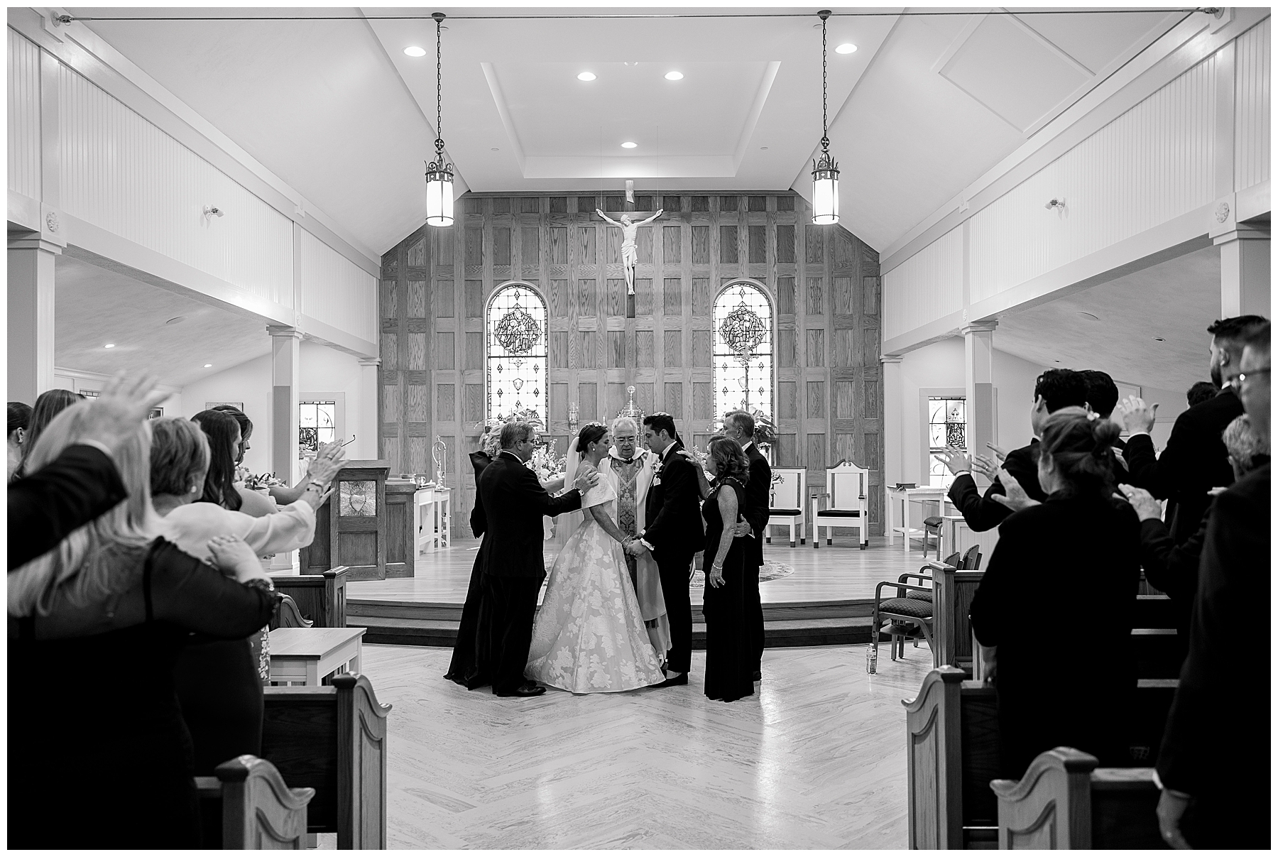 family prays over bride and groom