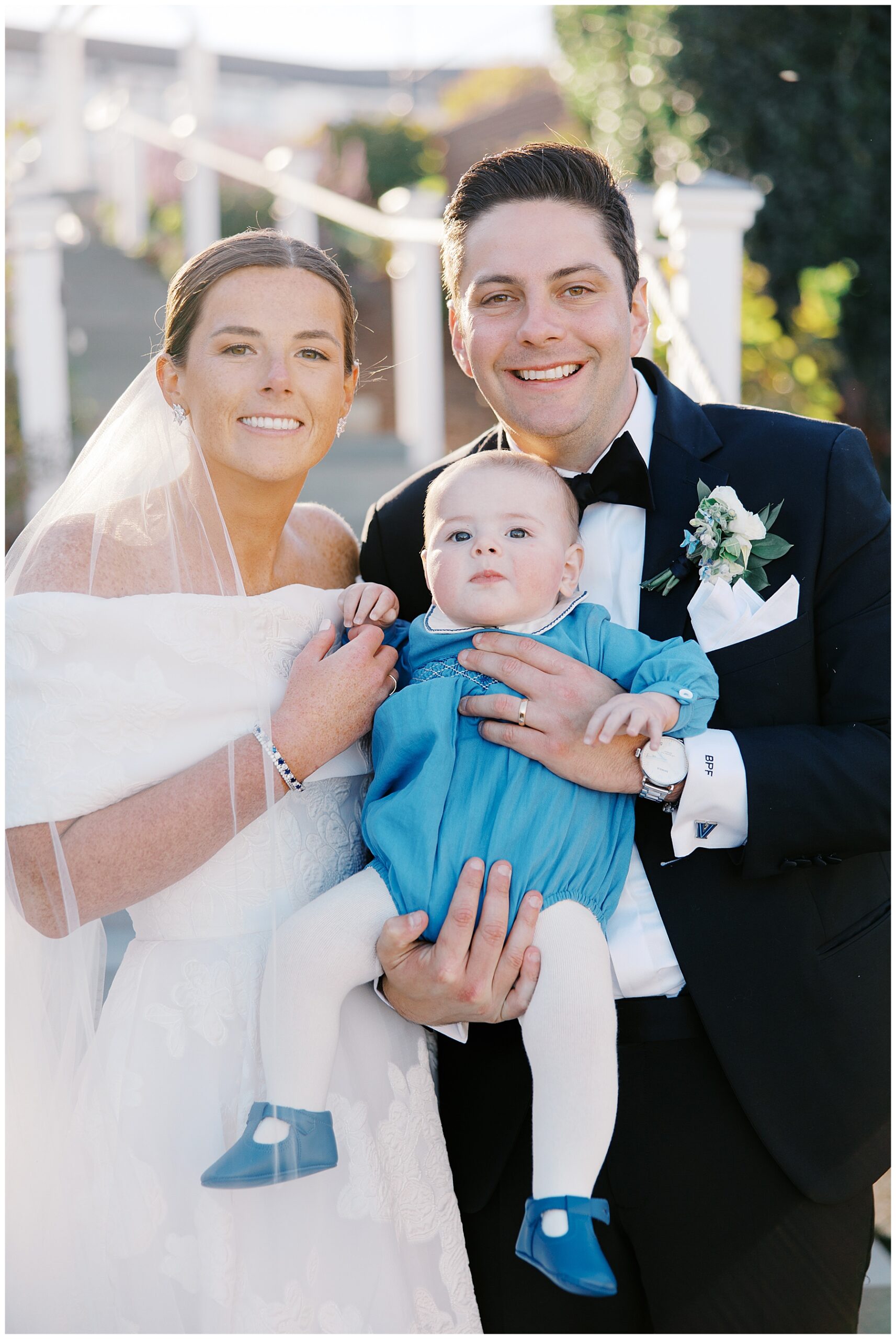 bride and groom hold baby 