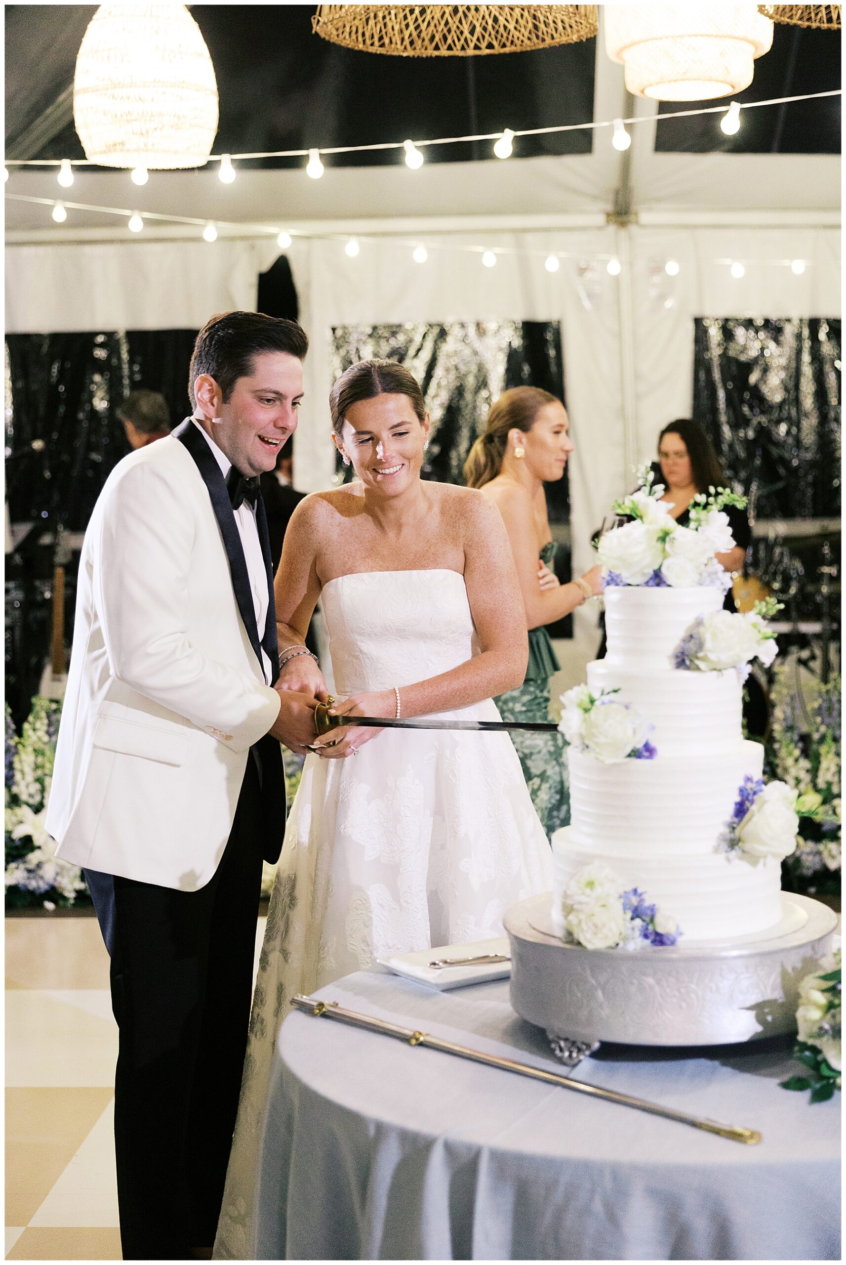 bride and groom cut wedding cake with sword 