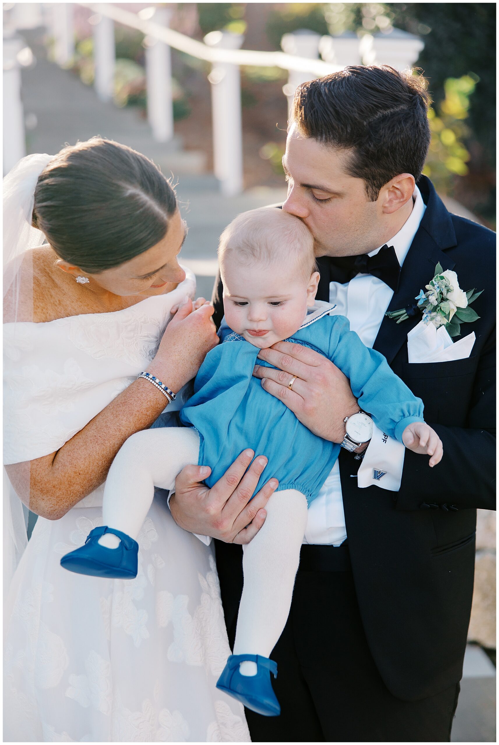 bride and groom hold baby 