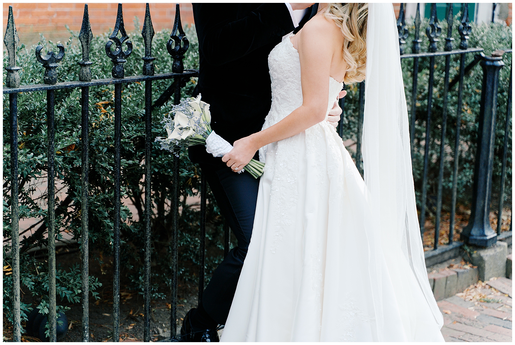 bride leans into groom holding classic bouquet