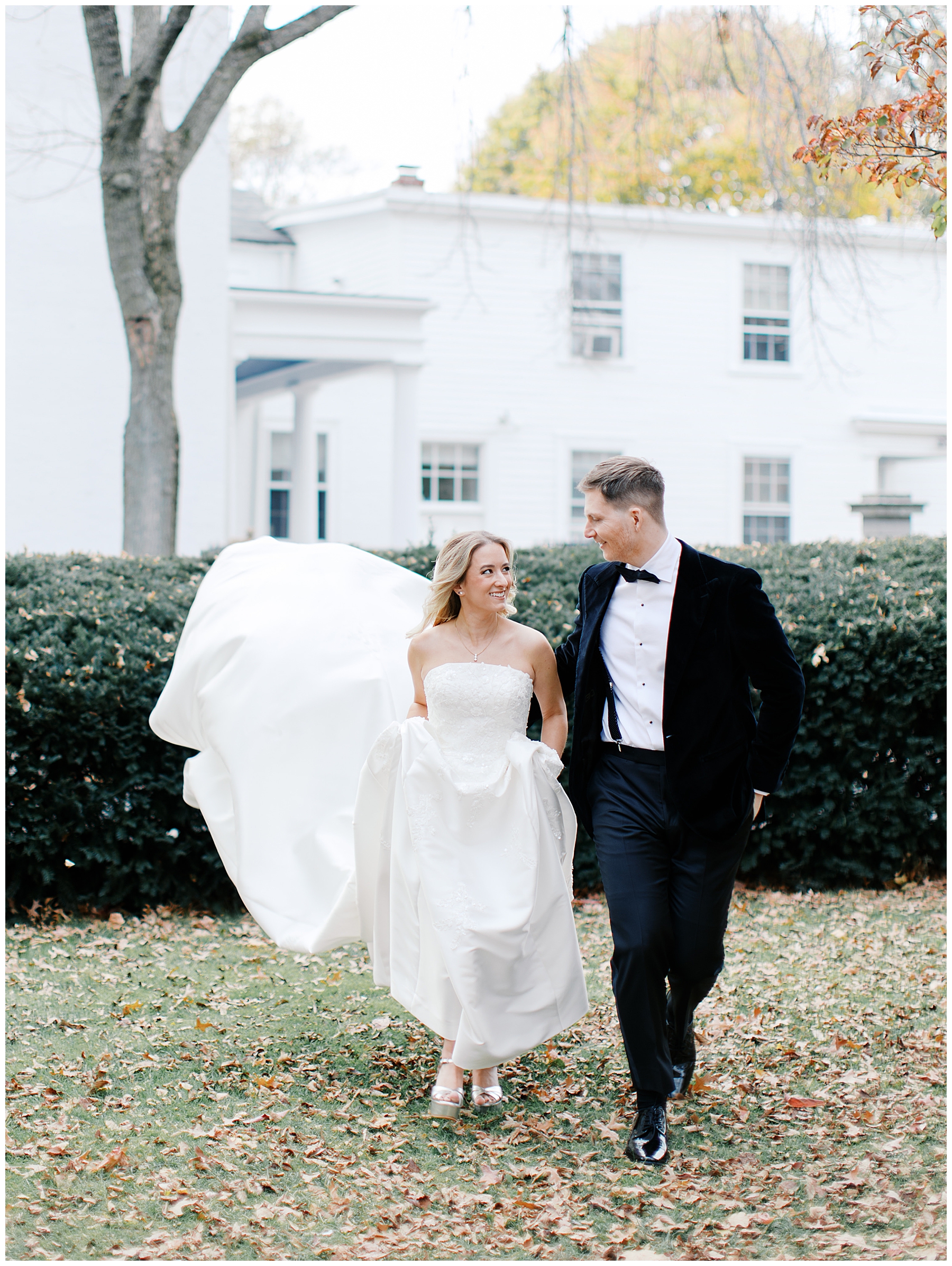 bride and groom walk across lawn