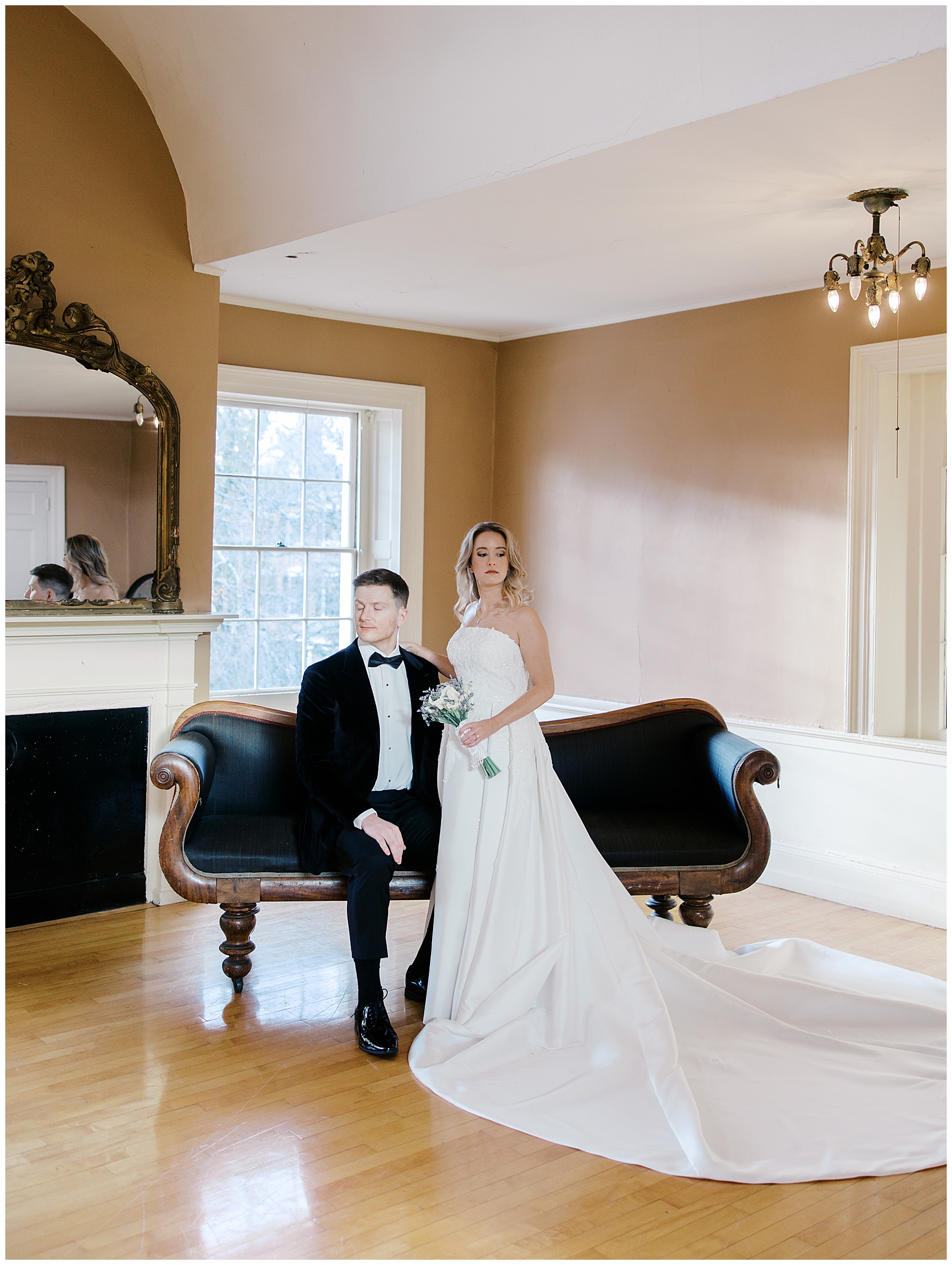 bride and groom sit on couch in historic Salem, MA wedding venue, Hamilton Hall