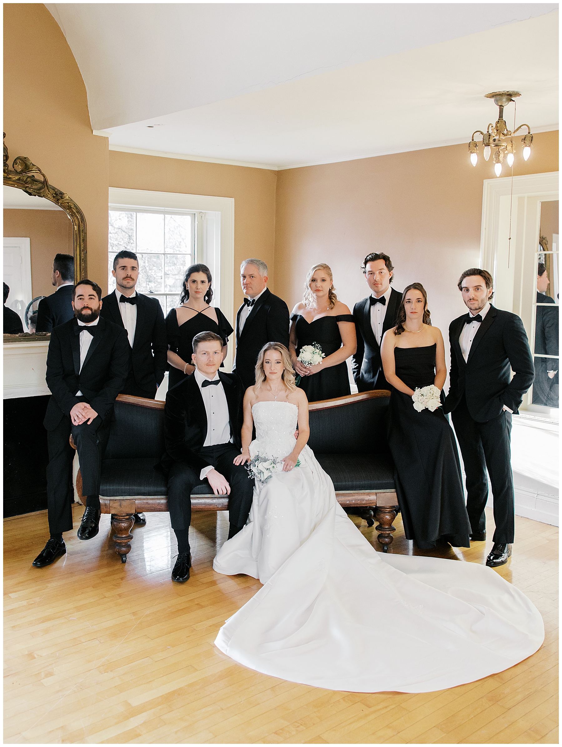 Wedding party portraits with bridesmaids in black dresses and groomsmen in black tuxes