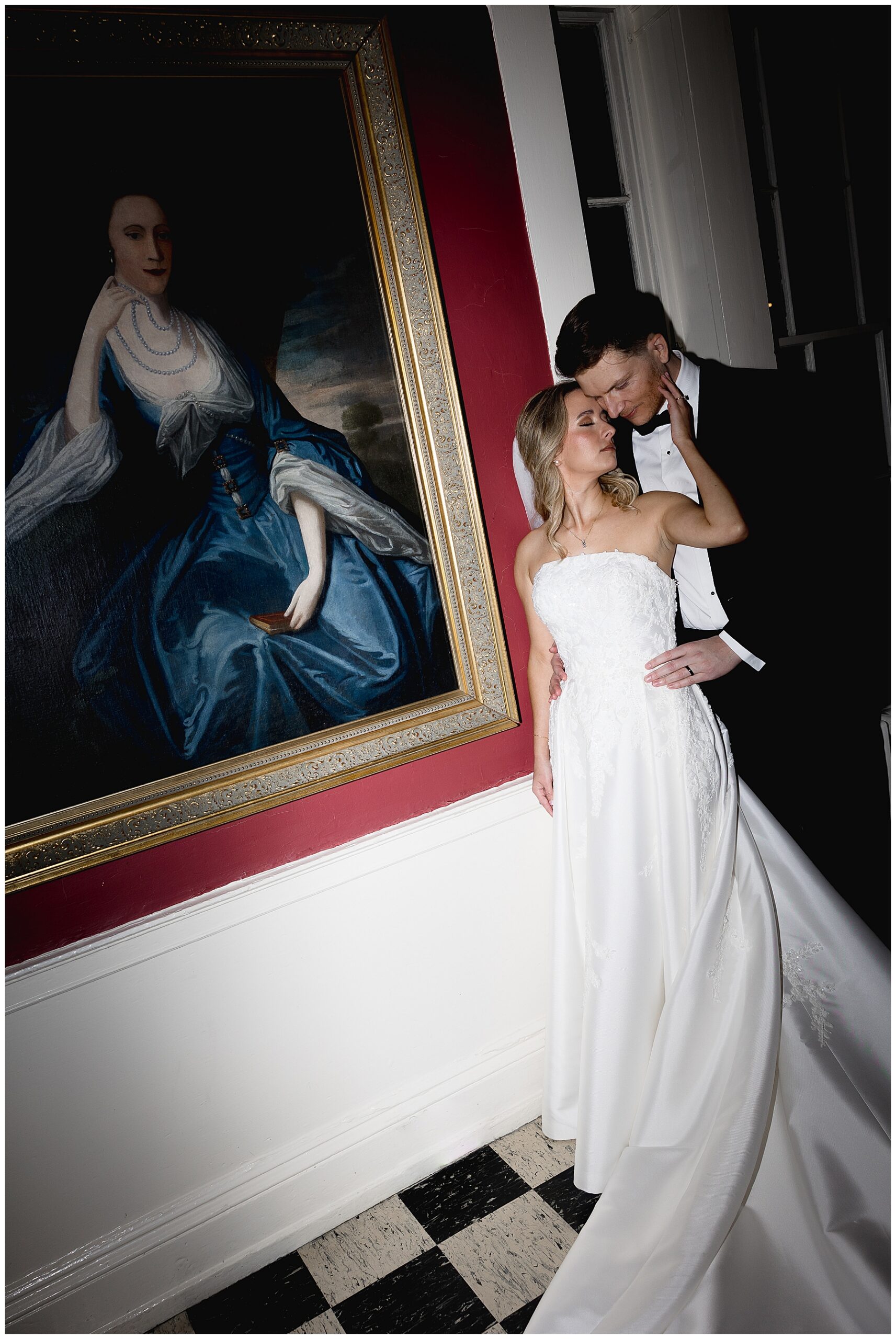 bride and groom stand by painting at Hamilton Hall