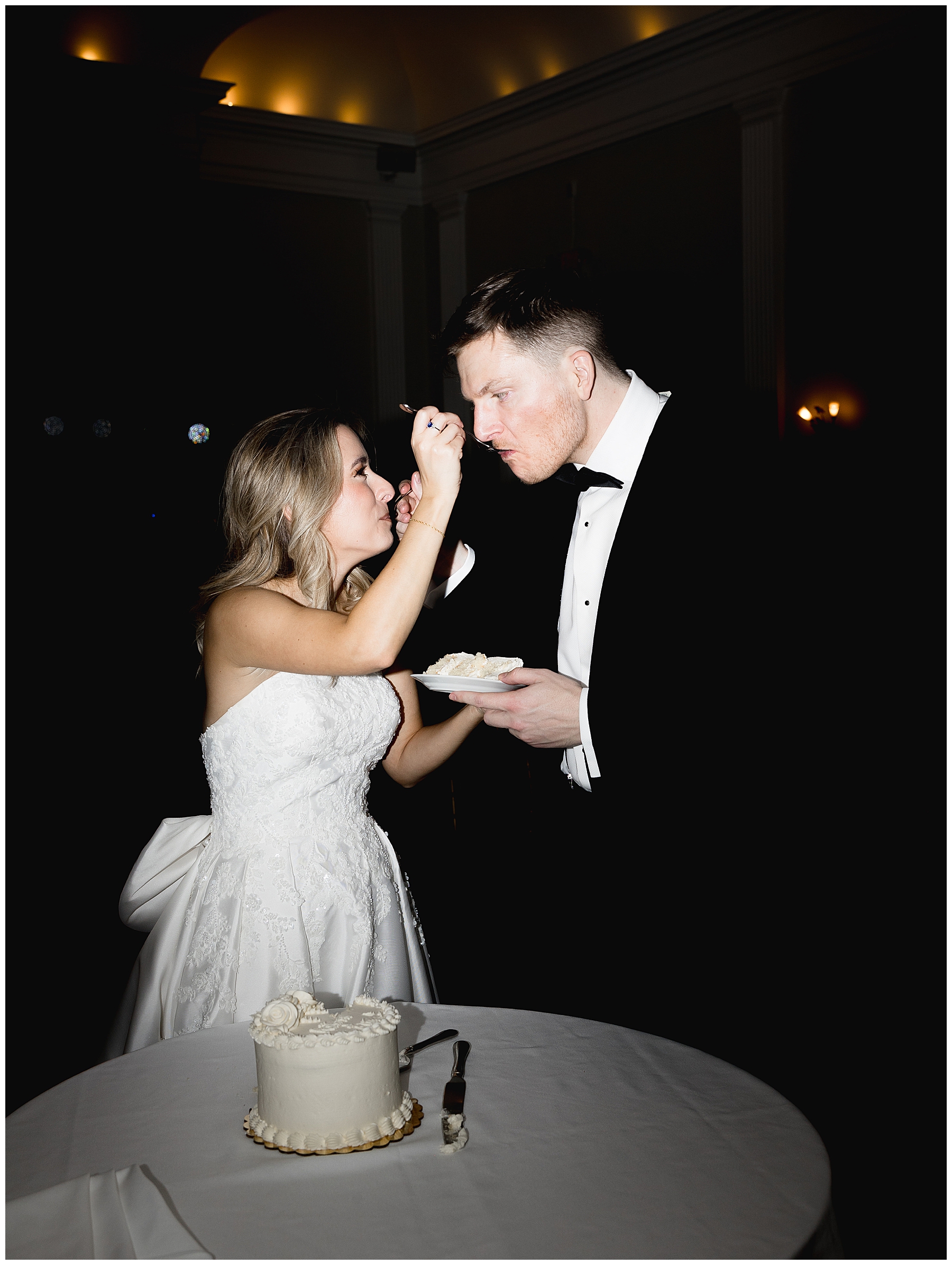 couple feed each other wedding cake
