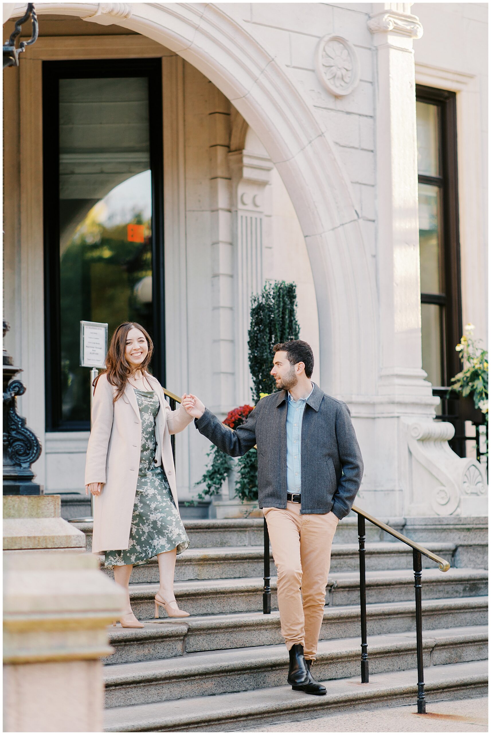 couple walk down steps of building in Boston