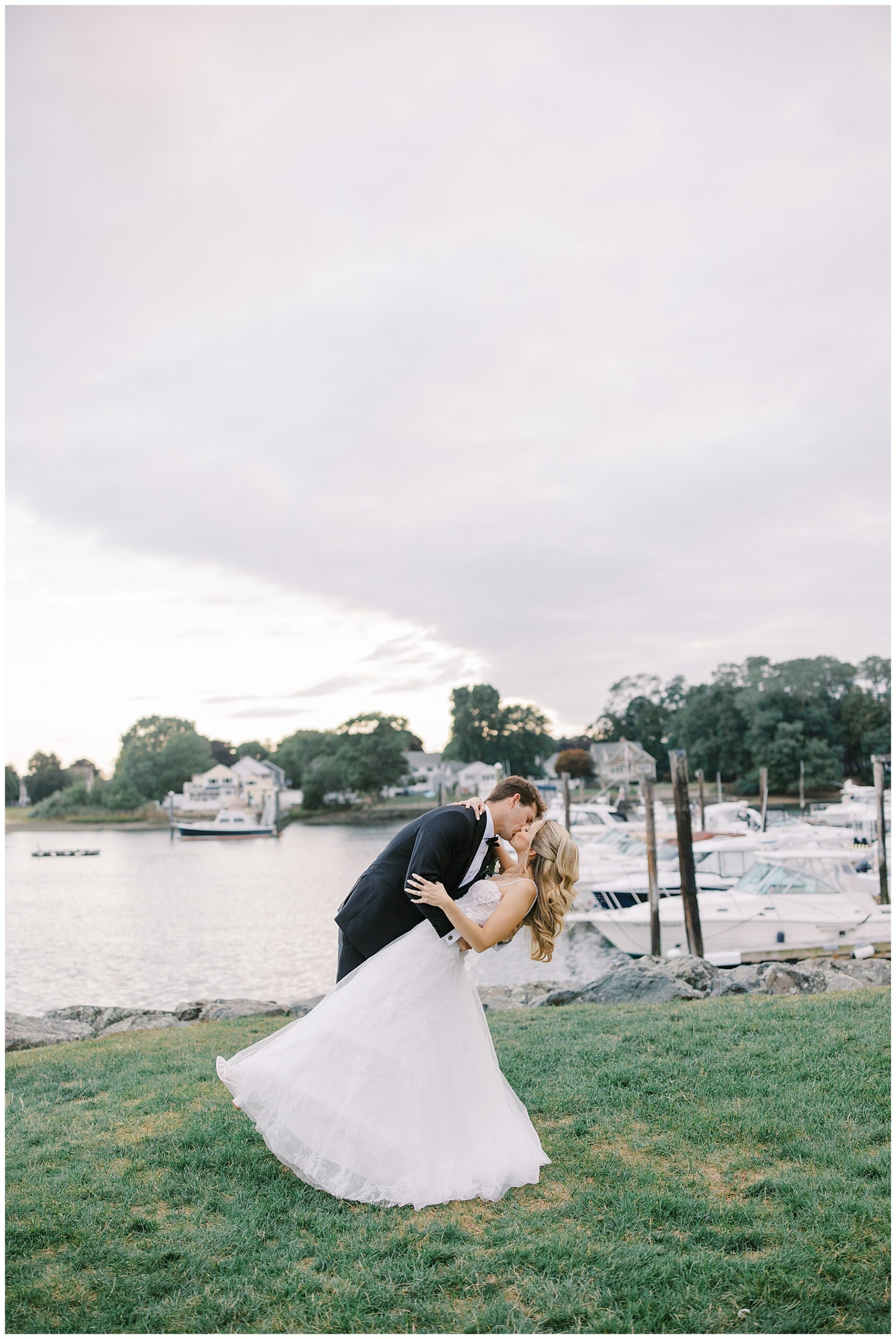 newlyweds kiss by the water at Danversport wedding on The North Shore