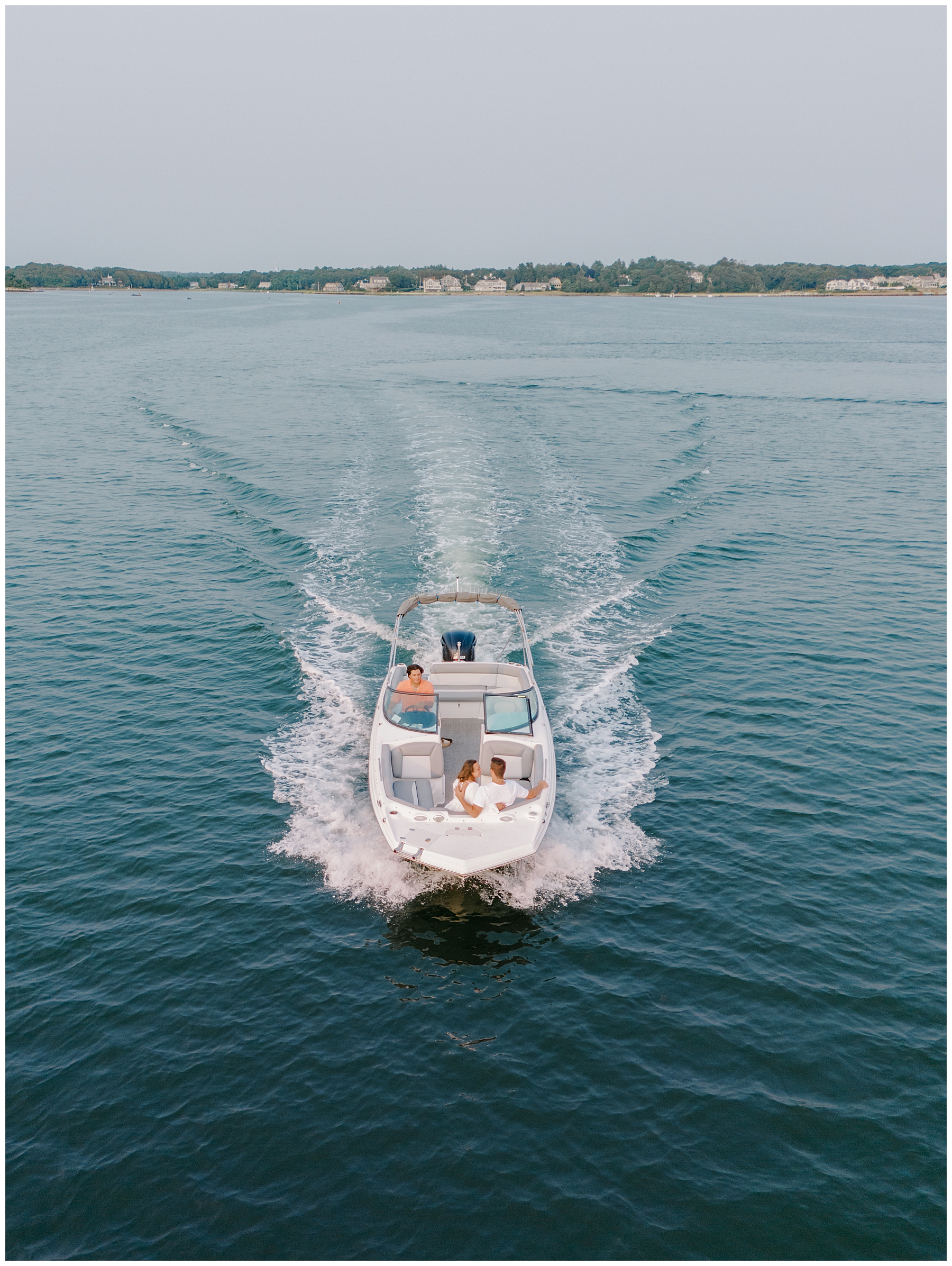 couple take a boat out on the water during engagement session 
