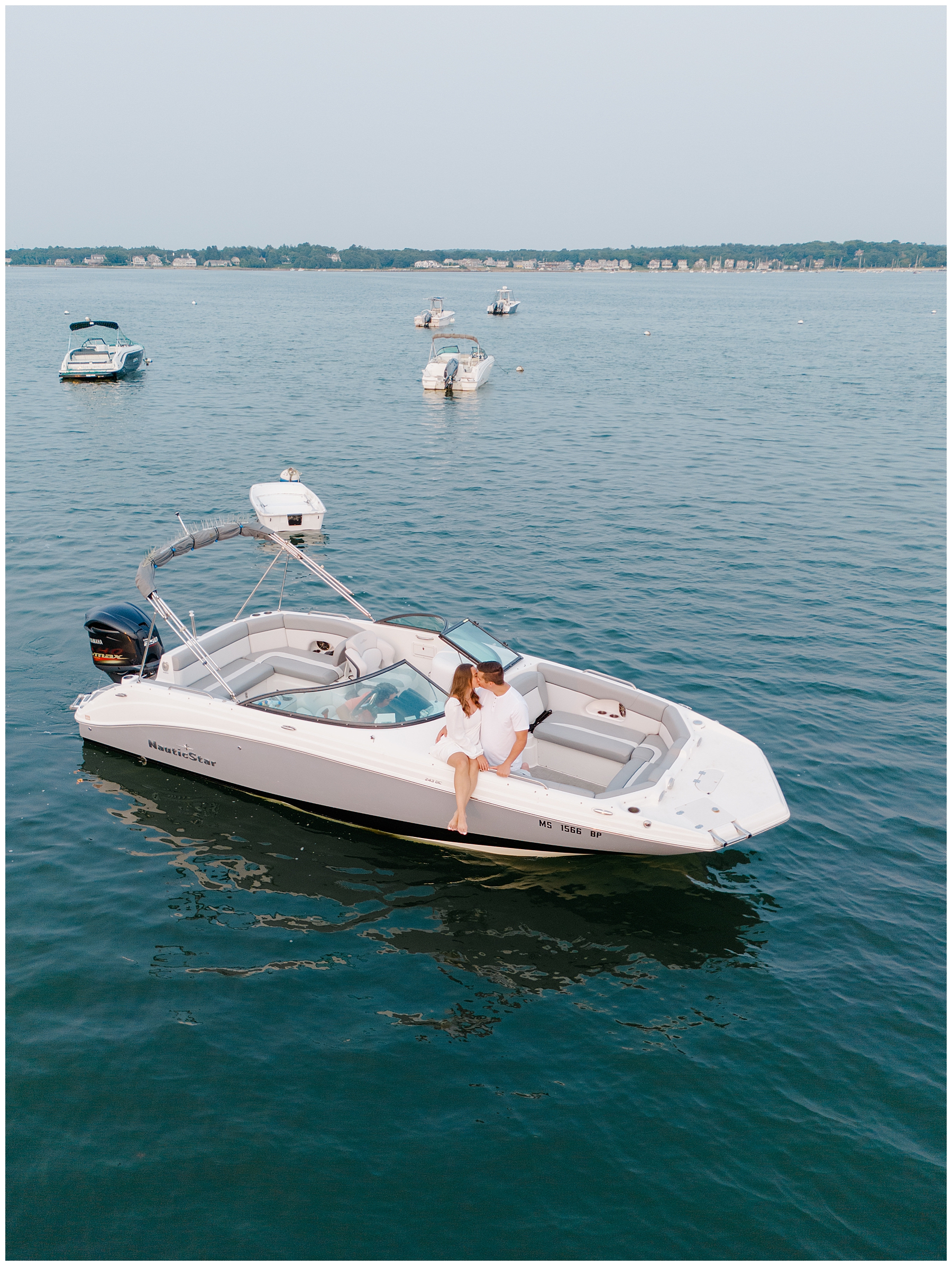 couple sit on boat for engagement portraits 