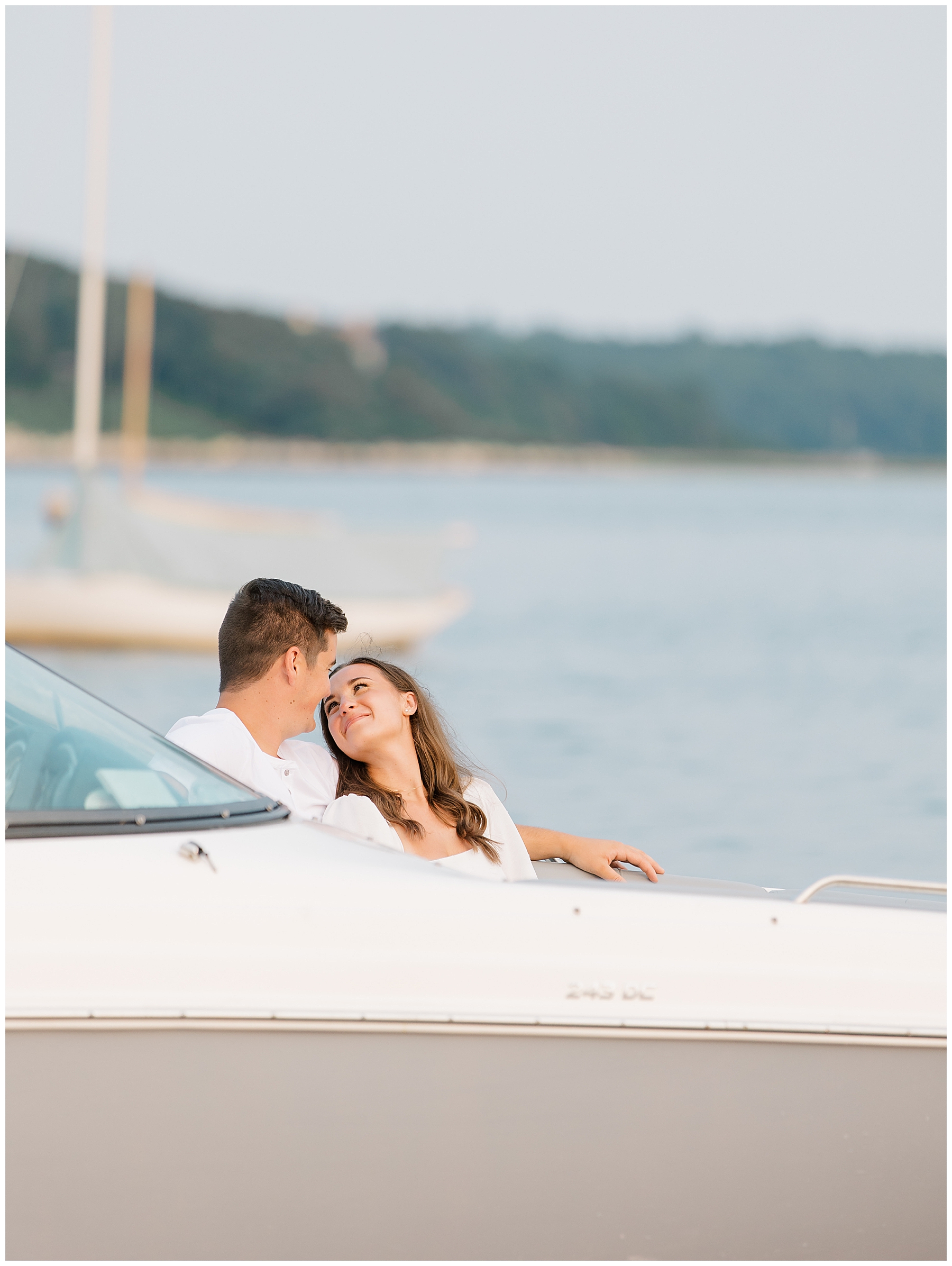 couple sit on boat during Coastal Engagement Session in Cape Cod