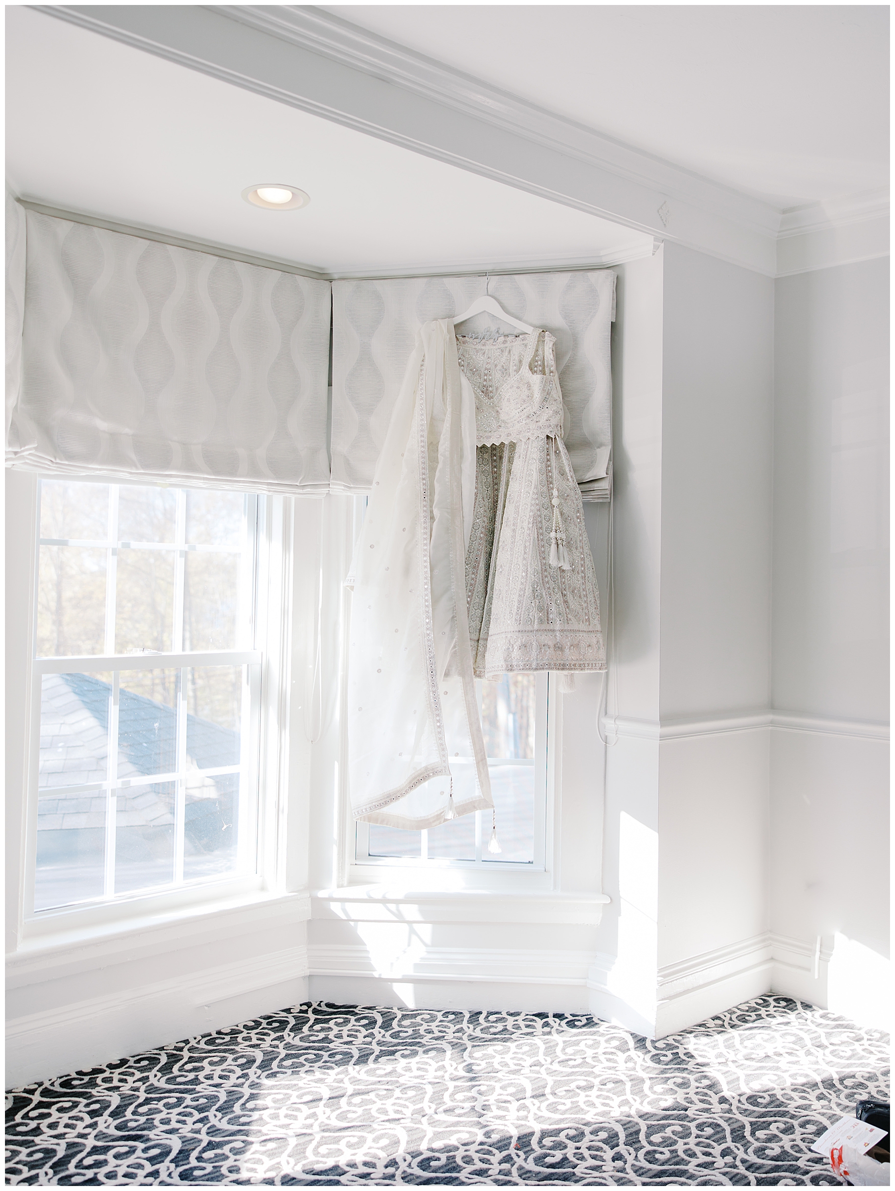 white and silver saree hanging by window