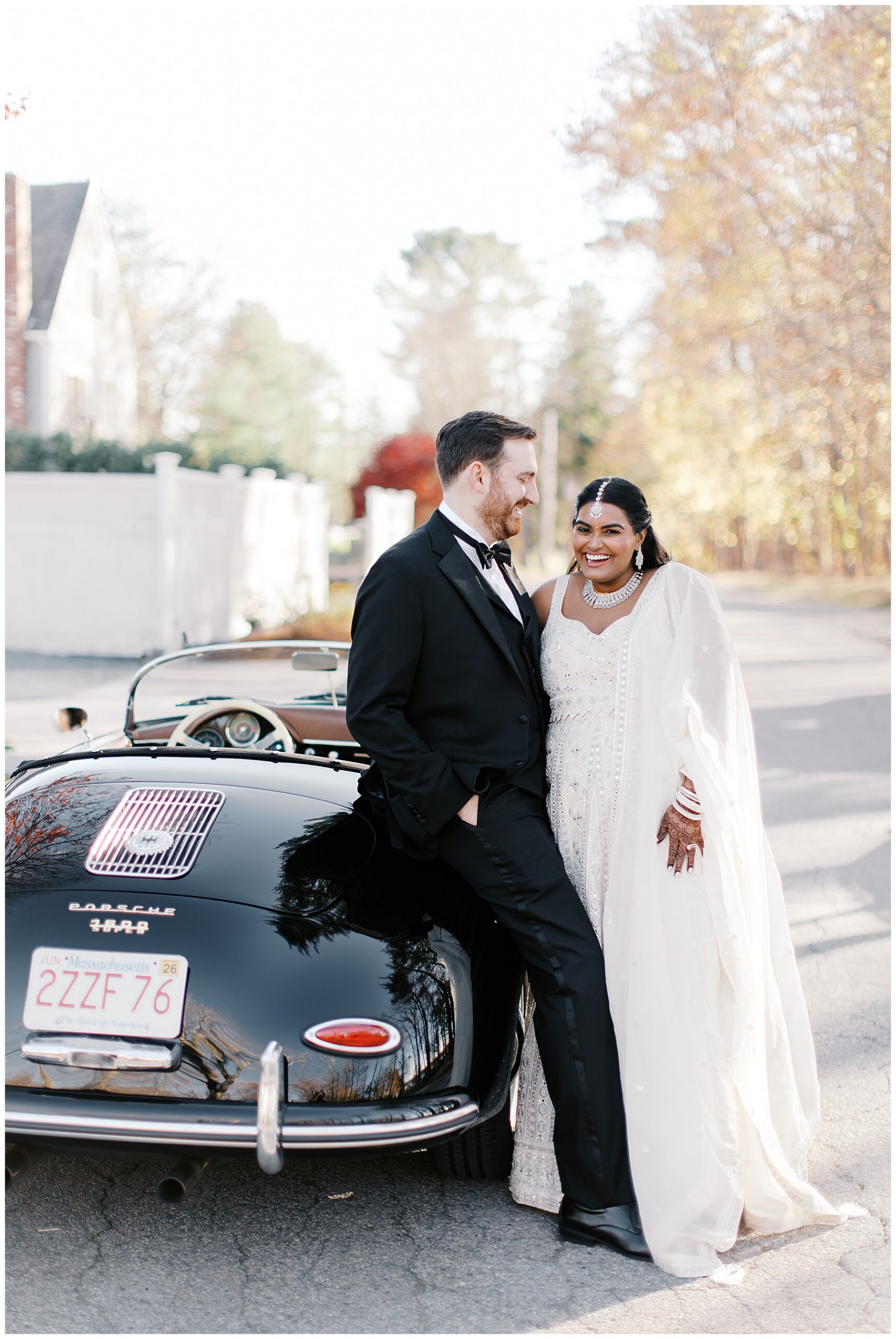 bride and groom lean against classic car