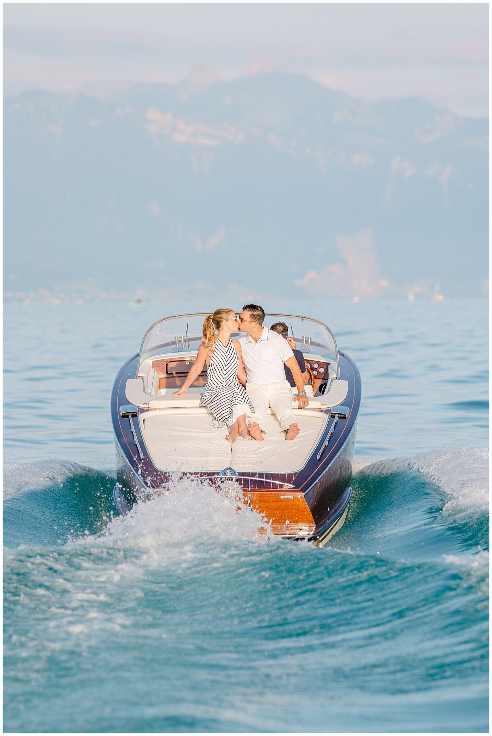 couple kiss on back of boat