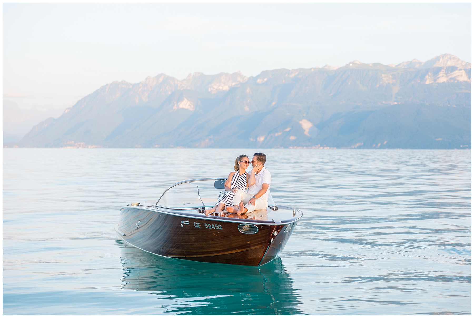 couple on boat on Lake Geneva with the Alps in the distance