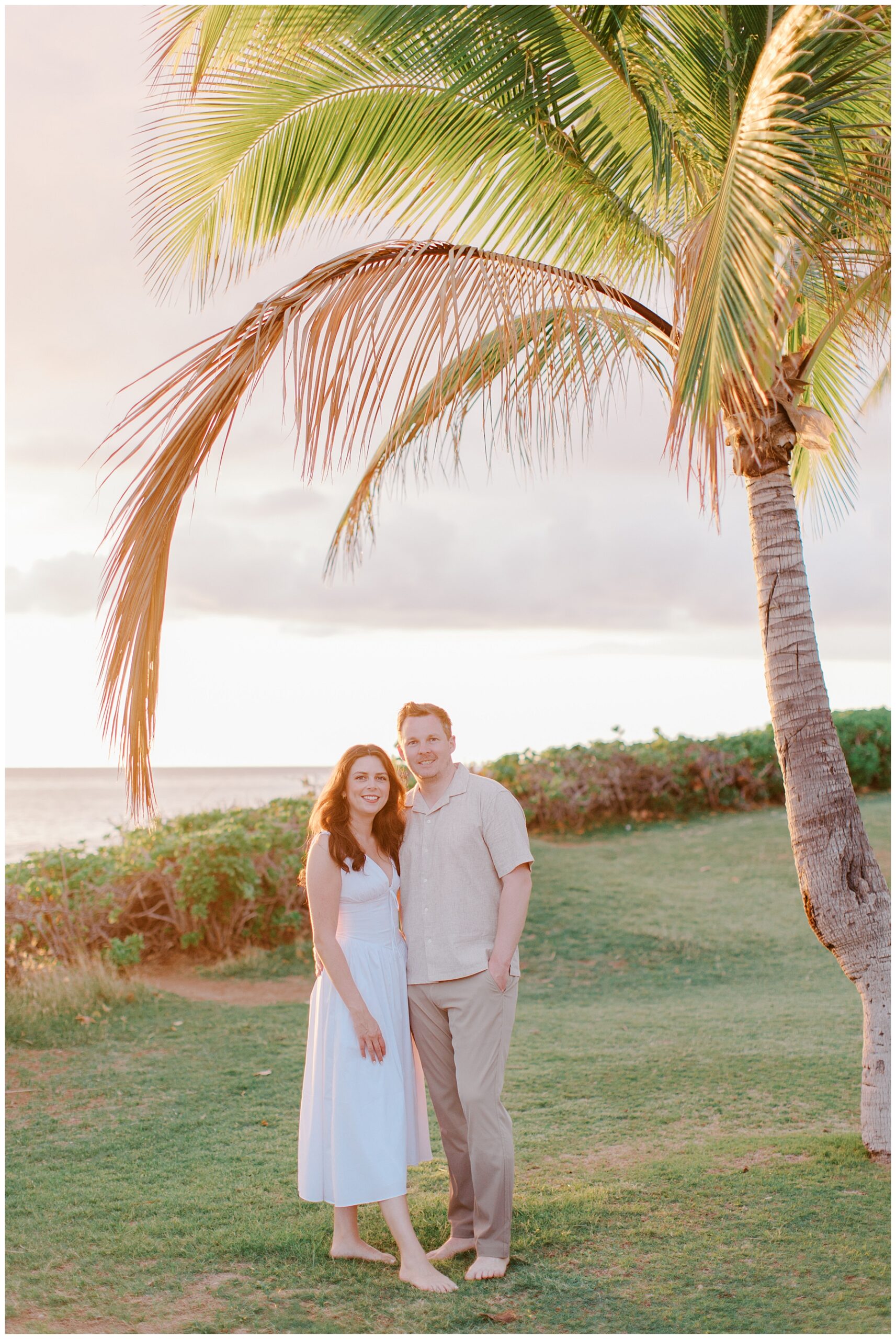 Ko Olina engagement photos of couple under palm tree