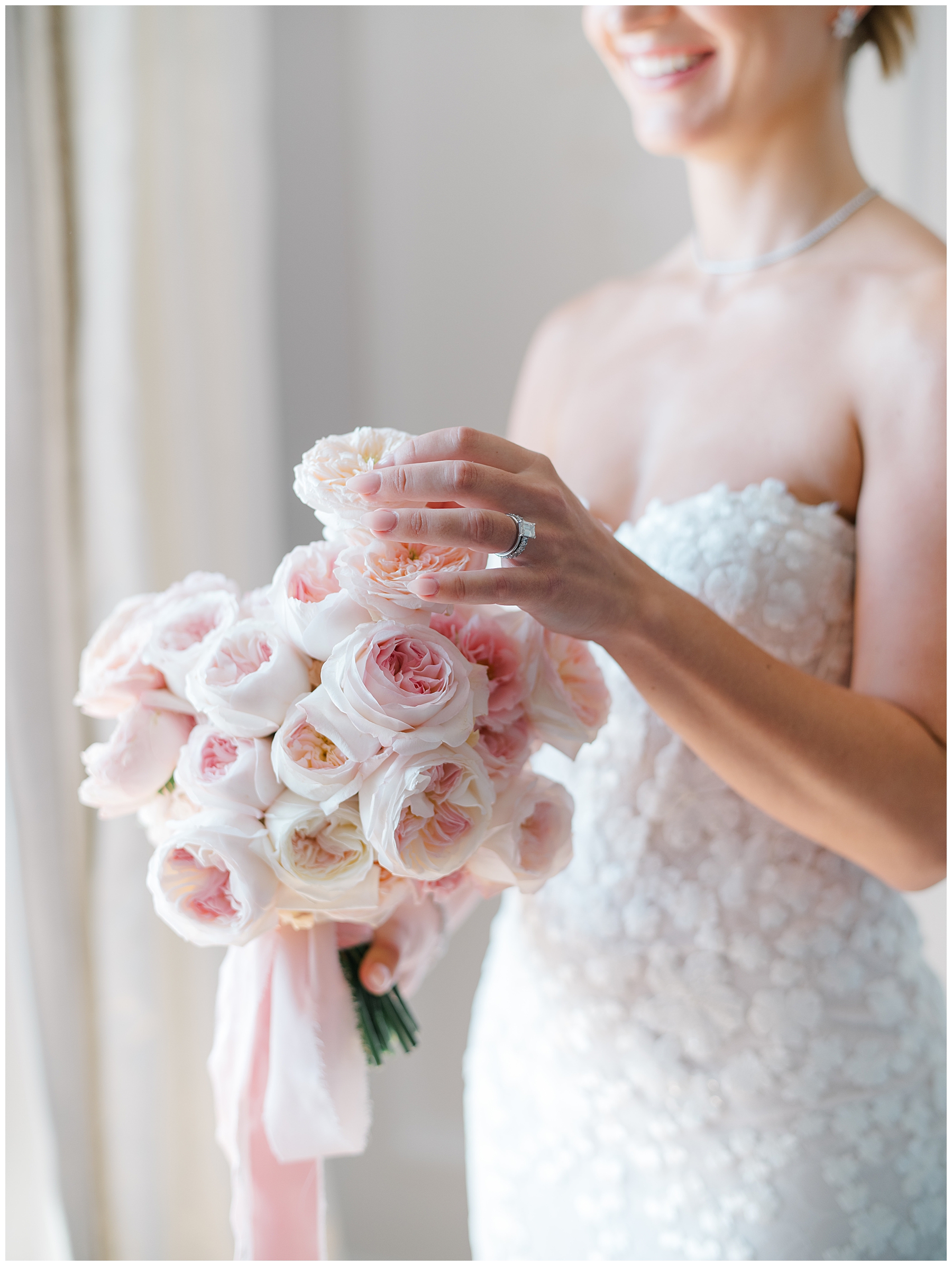 bride holding soft bridal bouquet of white light pink roses
