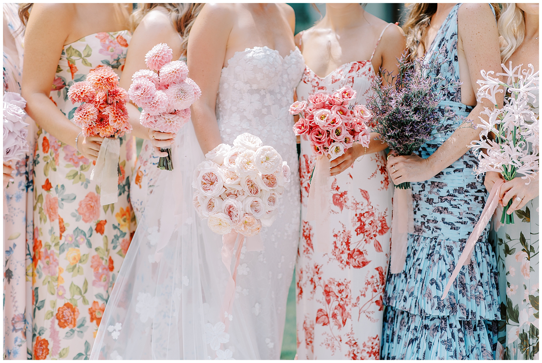 bride and bridesmaids in different floral dresses carrying coordinating wedding bouquets