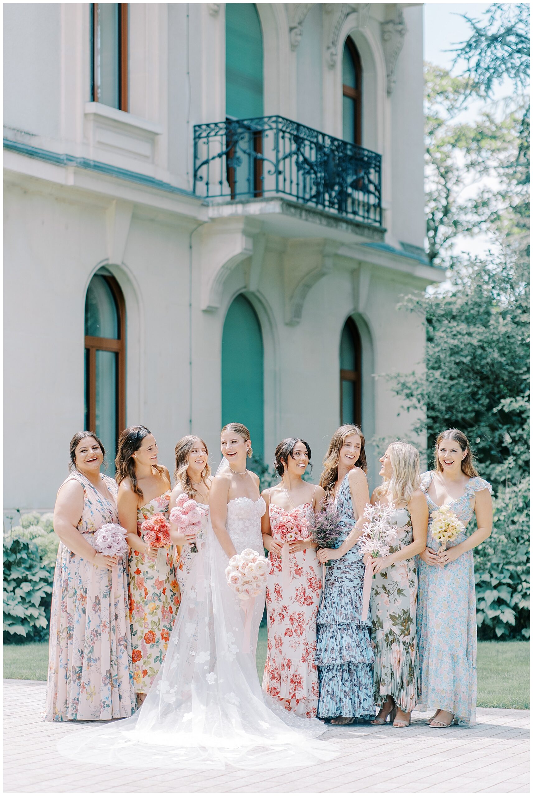 bride with bridesmaids in mismatched floral dresses holding different wedding bouquets that coordinate with dress
